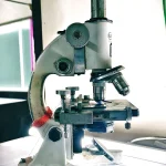 Scientist working at a scanning electron microscope in a laboratory