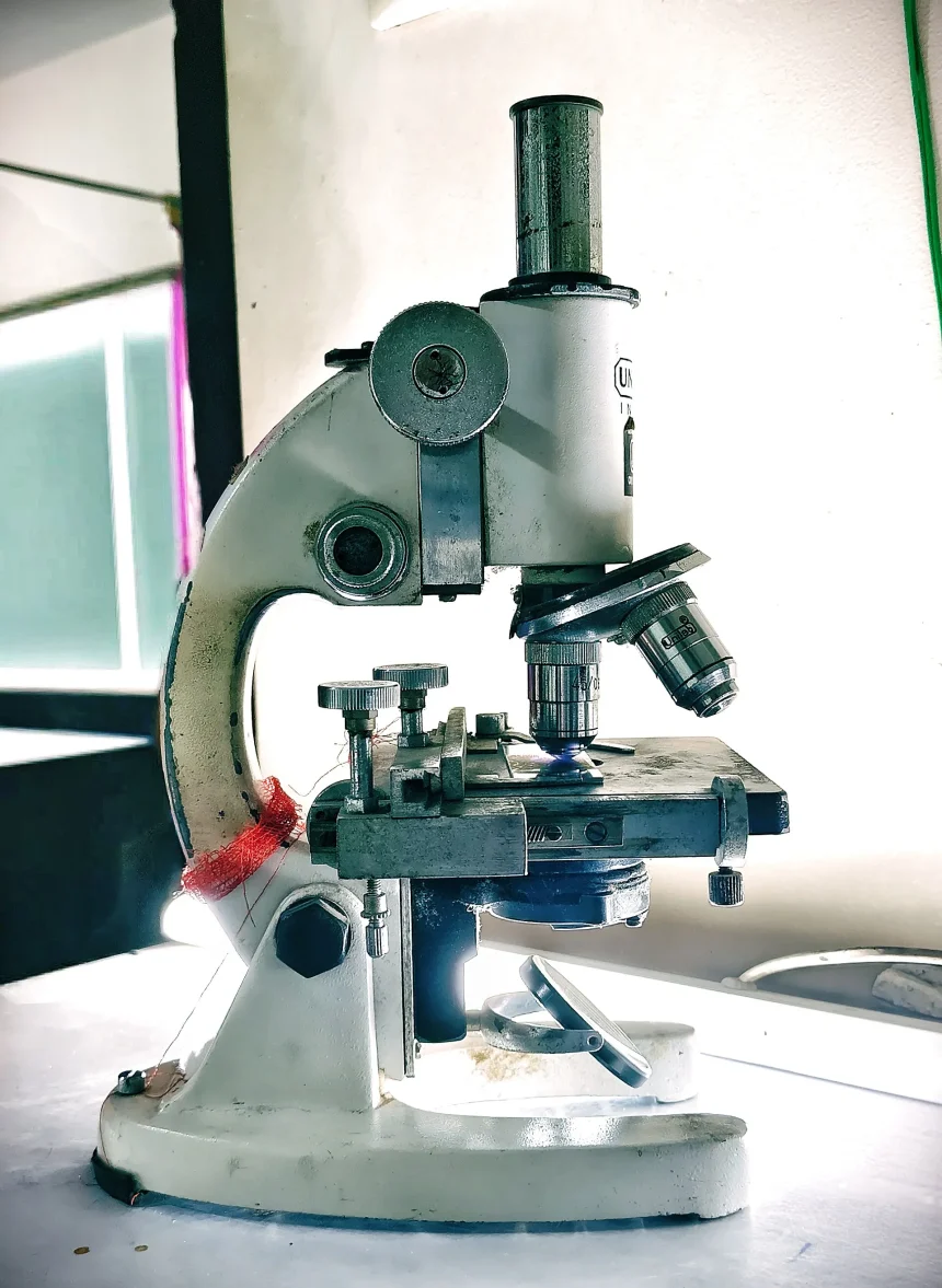 Scientist working at a scanning electron microscope in a laboratory